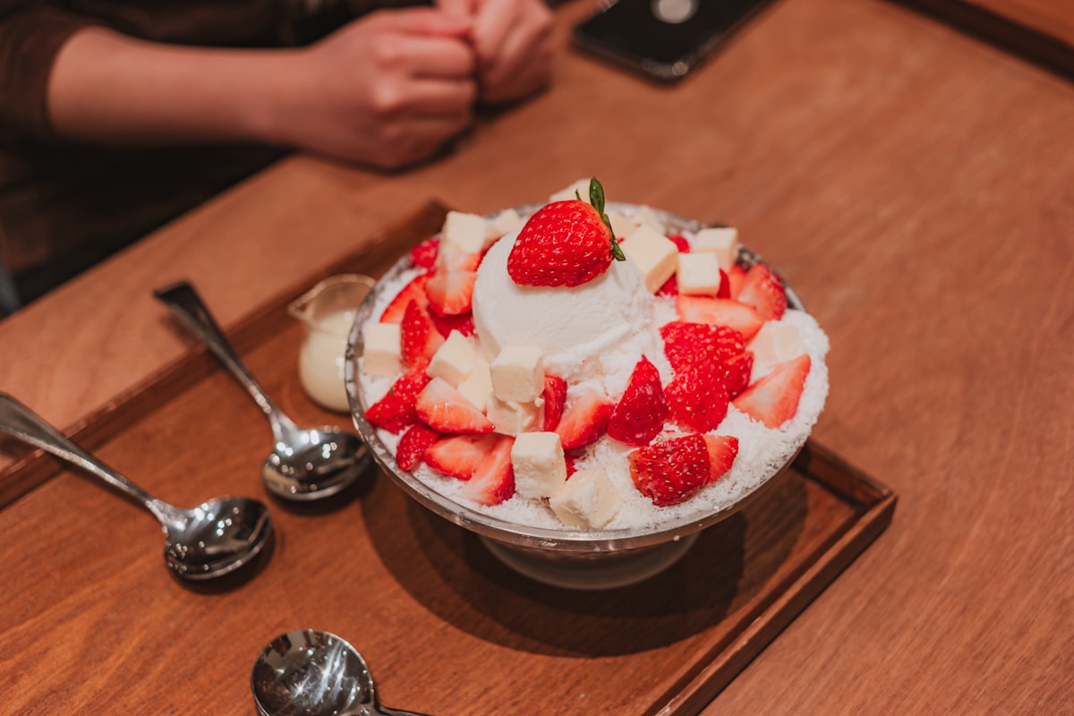 A bowl of Korean bingsu shaved ice with strawberries and cream